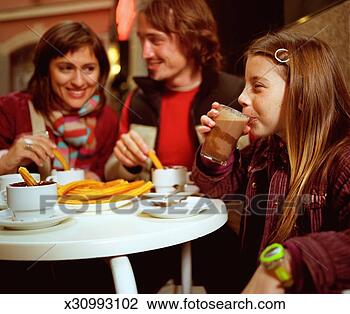 Stock Photo - girl (8-10) drinking 
chocolate drink 
in cafe, parents 
in background. 
fotosearch - search 
stock photos, 
pictures, images, 
and photo clipart