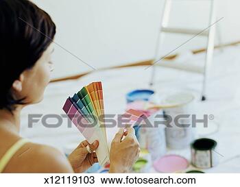 Stock Photo - young woman looking 
at paint colour 
cards, rear view 
(focus on cards). 
fotosearch - search 
stock photos, 
pictures, images, 
and photo clipart