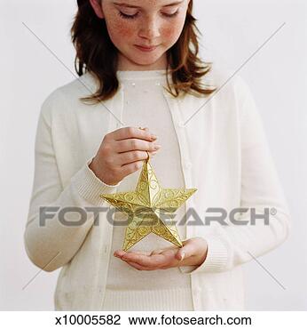 Stock Photo - girl (8-10) holding 
christmas ornament 
(focus on ornament). 
fotosearch - search 
stock photos, 
pictures, images, 
and photo clipart