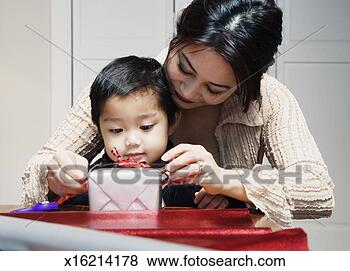 Stock Photo - mother showing 
son (2-4) how 
to tie bow on 
present. fotosearch 
- search stock 
photos, pictures, 
images, and photo 
clipart