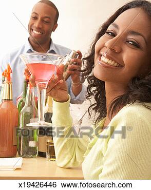 Stock Photo - young woman holding 
cocktail, young 
man holding cocktail 
shaker. fotosearch 
- search stock 
photos, pictures, 
images, and photo 
clipart