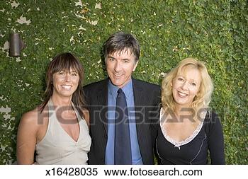 Stock Image - mature man standing 
with two mature 
women, smiling, 
portrait. fotosearch 
- search stock 
photos, pictures, 
images, and photo 
clipart