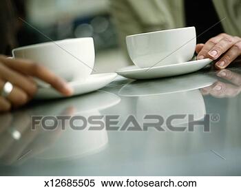 Stock Image - two young women 
holding coffee 
cups, close-up 
(focus on cups). 
fotosearch - search 
stock photos, 
pictures, images, 
and photo clipart