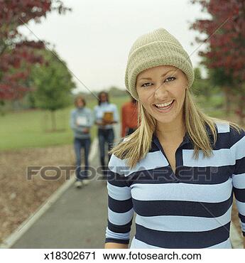 Stock Photography - young woman smiling, 
young adults carrying 
textbooks in background. 
fotosearch - search 
stock photos, 
pictures, images, 
and photo clipart