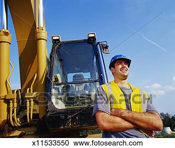 Stock Photography - male construction 
worker by construction 
equipment, smiling. 
fotosearch - search 
stock photos, 
pictures, images, 
and photo clipart