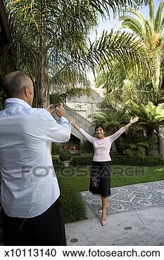 Stock Photography - mature man taking 
photograph of 
mature woman in 
courtyard. fotosearch 
- search stock 
photos, pictures, 
images, and photo 
clipart