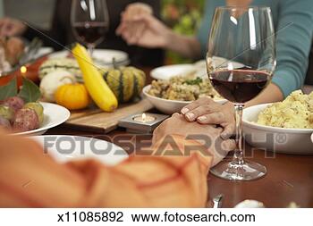 Stock Photo - people holding 
hands at dining 
table, mid section, 
focus on hands. 
fotosearch - search 
stock photos, 
pictures, images, 
and photo clipart