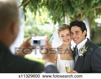 Stock Photography - man photographing 
bride and groom 
(focus on bride 
and groom). fotosearch 
- search stock 
photos, pictures, 
images, and photo 
clipart