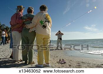 Stock Photo - mature man photographing 
three mature women 
at beach, dusk. 
fotosearch - search 
stock photos, 
pictures, images, 
and photo clipart
