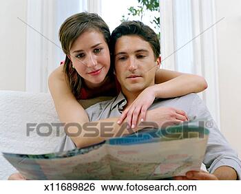 Stock Photo - young couple looking 
at map, close-up 
(focus on couple). 
fotosearch - search 
stock photos, 
pictures, images, 
and photo clipart