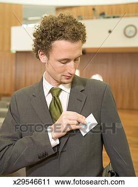 Stock Photography - young man placing 
name card on jacket. 
fotosearch - search 
stock photos, 
pictures, images, 
and photo clipart