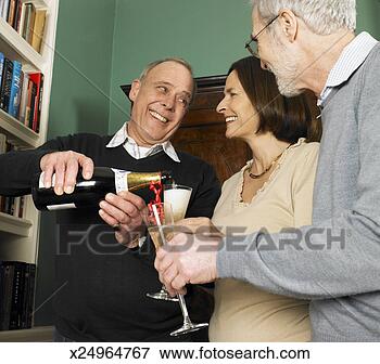 Picture - mature man pouring 
champagne for 
mature woman and 
senior man, smiling. 
fotosearch - search 
stock photos, 
pictures, images, 
and photo clipart