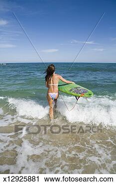 Stock Photography - mexico, baja, 
woman carrying 
surfboard into 
sea, rear view. 
fotosearch - search 
stock photos, 
pictures, images, 
and photo clipart