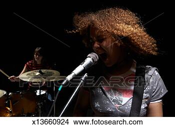 Stock Photo - two teenage girls 
(14-16), one girl 
playing drums, 
one girl singing. 
fotosearch - search 
stock photos, 
pictures, images, 
and photo clipart