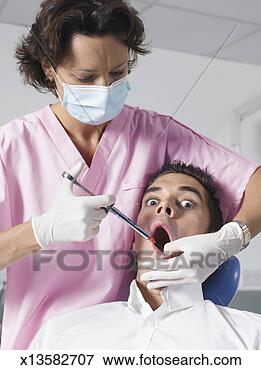 Picture - dentist injecting 
man's mouth, man 
with alarmed expression 
on face. fotosearch 
- search stock 
photos, pictures, 
images, and photo 
clipart