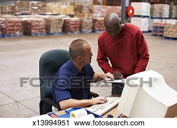 Stock Photography - man checking file 
with mature man 
sitting at desk 
in warehouse. 
fotosearch - search 
stock photos, 
pictures, images, 
and photo clipart