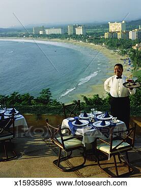 Stock Image - mexico, ixtapa, 
waiter with drinks 
on terrace overlooking 
beach. fotosearch 
- search stock 
photos, pictures, 
images, and photo 
clipart
