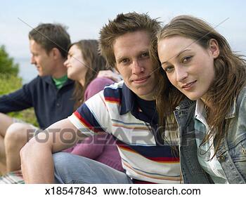 Stock Photo - young couples 
sitting on wall 
(focus on couple 
in foreground). 
fotosearch - search 
stock photos, 
pictures, images, 
and photo clipart