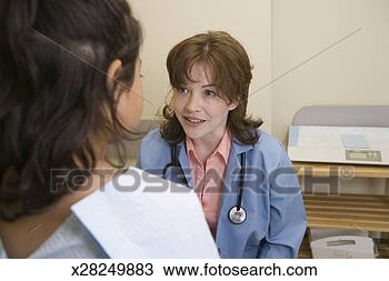 Stock Photo - female doctor 
talking to girl 
(7-9) in exam 
room (focus on 
doctor). fotosearch 
- search stock 
photos, pictures, 
images, and photo 
clipart