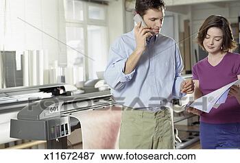 Picture - male and female 
office workers 
looking at printed 
work,  man using. 
fotosearch - search 
stock photos, 
pictures, images, 
and photo clipart