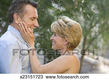 Stock Photo - mature woman touching 
mature man's cheek, 
smiling, side 
view. fotosearch 
- search stock 
photos, pictures, 
images, and photo 
clipart