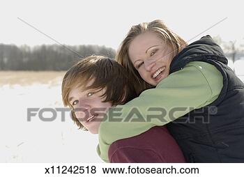Stock Photo - teenage boy (14-16) 
giving teenage 
girl (14-16) piggyback 
in snow. fotosearch 
- search stock 
photos, pictures, 
images, and photo 
clipart