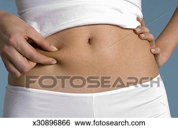 Stock Photo - young woman pinching 
skin on tummy, 
mid section. fotosearch 
- search stock 
photos, pictures, 
images, and photo 
clipart