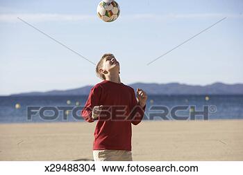 Stock Photo - boy (11-13) bouncing 
soccer ball on 
beach, focus on 
boy. fotosearch 
- search stock 
photos, pictures, 
images, and photo 
clipart