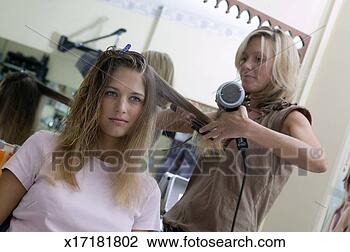 Stock Photo - female hair stylist 
drying young woman's 
hair. fotosearch 
- search stock 
photos, pictures, 
images, and photo 
clipart