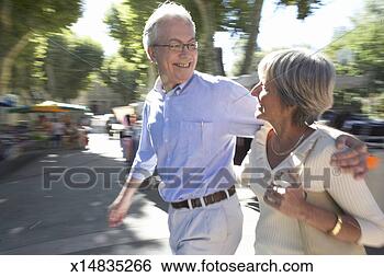 Stock Photo - mature couple 
walking down street, 
focus on couple. 
fotosearch - search 
stock photos, 
pictures, images, 
and photo clipart