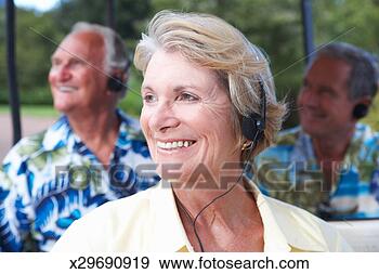 Stock Photograph - senior woman with 
other senior men, 
 listening to 
tour on headphones. 
fotosearch - search 
stock photos, 
pictures, images, 
and photo clipart