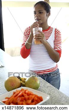 Stock Photo - teenage girl (15-17) 
drinking fruit 
drink in kitchen. 
fotosearch - search 
stock photos, 
pictures, images, 
and photo clipart