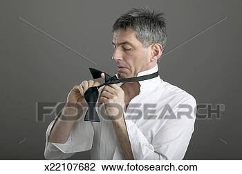 Stock Photo - mature man trying 
to tie bow tie. 
fotosearch - search 
stock photos, 
pictures, images, 
and photo clipart