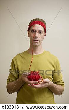 Picture - mature man wearing 
red headband and 
holding ball of 
red wool, portrait. 
fotosearch - search 
stock photos, 
pictures, images, 
and photo clipart