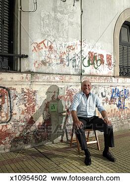 Stock Photo - mature man sitting 
against wall with 
graffiti smiling, 
portrait. fotosearch 
- search stock 
photos, pictures, 
images, and photo 
clipart