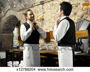 Stock Photo - two waiters tying 
bow ties in restaurant, 
smiling. fotosearch 
- search stock 
photos, pictures, 
images, and photo 
clipart