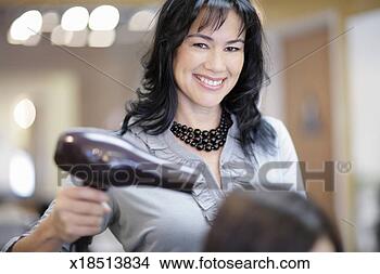 Stock Photo - female hair stylist 
drying customer's 
hair in hair salon. 
fotosearch - search 
stock photos, 
pictures, images, 
and photo clipart