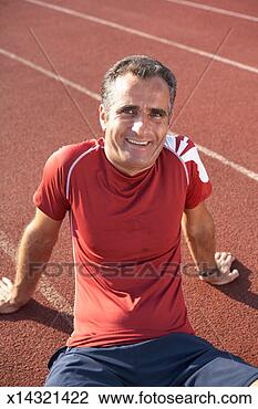 Stock Photo - mid adult man 
sitting on track 
at track and field 
stadium,  smiling. 
fotosearch - search 
stock photos, 
pictures, images, 
and photo clipart