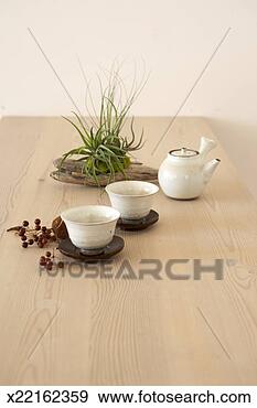 Stock Photograph - small japanese 
teapot and two 
teacups with small 
plant on wooden 
table. fotosearch 
- search stock 
photos, pictures, 
images, and photo 
clipart