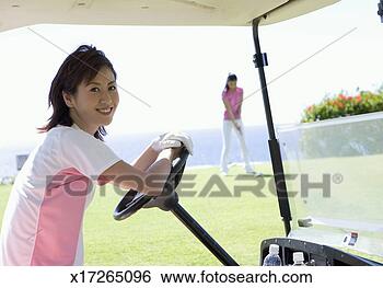 Stock Photo - woman sitting 
in golfcart while 
other playing 
golf in background. 
fotosearch - search 
stock photos, 
pictures, images, 
and photo clipart