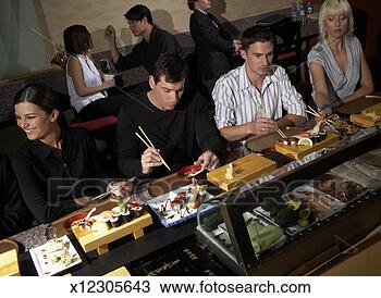 Stock Photo - four people sitting 
at counter in 
sushi bar, others 
in background. 
fotosearch - search 
stock photos, 
pictures, images, 
and photo clipart