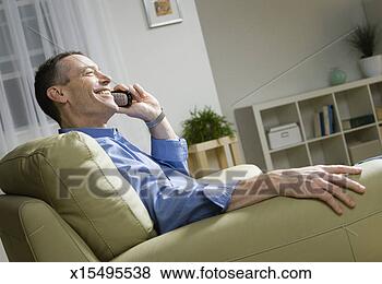 Stock Photo - mature man using 
phone in living 
room. fotosearch 
- search stock 
photos, pictures, 
images, and photo 
clipart