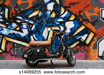 Stock Image - motor scooter 
parked in front 
of wall covered 
with colourful 
graffiti. fotosearch 
- search stock 
photos, pictures, 
images, and photo 
clipart