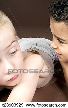 Stock Photograph - two boys (6-7) 
lying down,  one 
boy looking at 
cicada on other 
boy's. fotosearch 
- search stock 
photos, pictures, 
images, and photo 
clipart