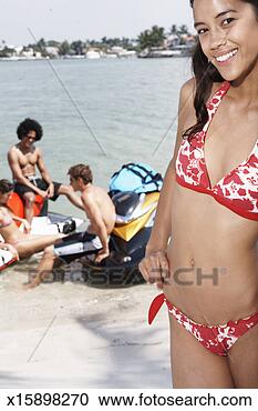 Stock Photography - young woman in 
bikini,  portrait, 
 out of focus 
friends in background. 
fotosearch - search 
stock photos, 
pictures, images, 
and photo clipart