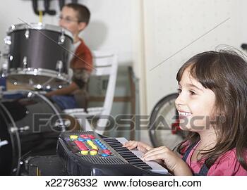 Stock Photo - girl (4-5) playing 
keyboard,  out 
of focus boy (8-9) 
playing drums 
in. fotosearch 
- search stock 
photos, pictures, 
images, and photo 
clipart