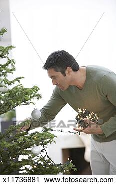 Stock Photography - mature man putting 
lights on christmas 
tree. fotosearch 
- search stock 
photos, pictures, 
images, and photo 
clipart