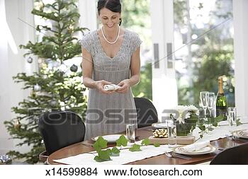 Stock Photo - mature woman setting 
dinner table for 
christmas dinner. 
fotosearch - search 
stock photos, 
pictures, images, 
and photo clipart