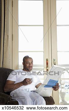 Stock Photo - mid adult man 
sitting in armchair 
reading newspaper 
in front of. fotosearch 
- search stock 
photos, pictures, 
images, and photo 
clipart