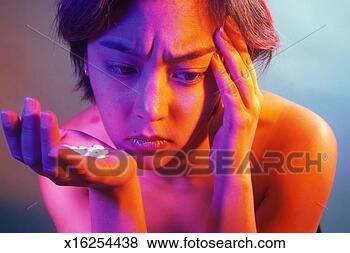Stock Photo - woman with headache 
holding pills 
in hand. fotosearch 
- search stock 
photos, pictures, 
images, and photo 
clipart